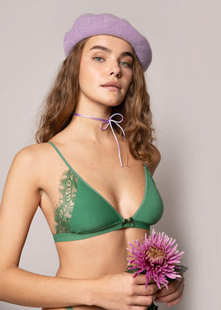Woman wears green bralette with jersey cups and lace details at the outer side of the cups. This lingerie looks sporty but elegant at the same time and is from Lioa Lingerie, a Swiss Lingerie Brand.