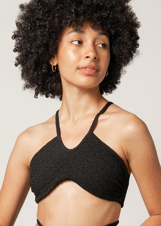 woman wears black sporty bikini top with textured fabric