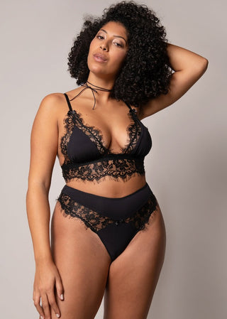 Curvy woman in black lace bralette with high waist thong looking very confident and elegant.
