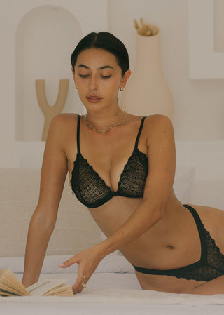 Woman wears a classic black bralette with embroidery that looks very comfortable. The elegant bralette is from Lioa Lingerie, a Swiss Lingerie Brand.
