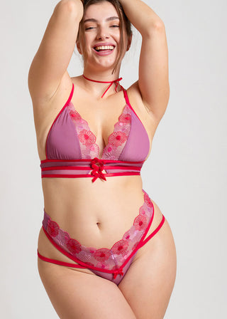 Happy curvy woman in red and pink underwear set with playful bow details and sexy straps. 