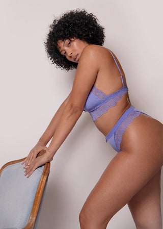 curvy model looks confident in purple lace underwear.