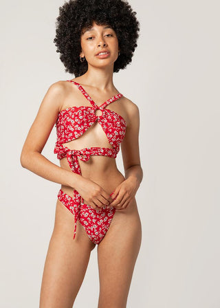 woman wears bikini top in red to wrap around chest 