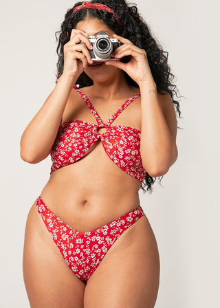 curvy woman wear red wrap bikini top with floral details and takes a photo