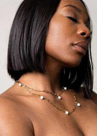 model looks confident wearing golden pearl bodychain as a necklace.