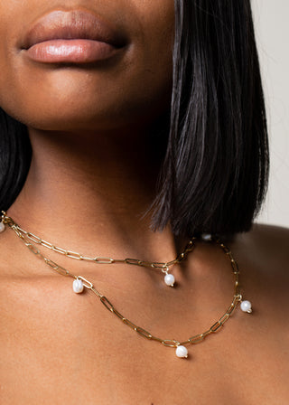 model wears golden pearl bodychain as a necklace.